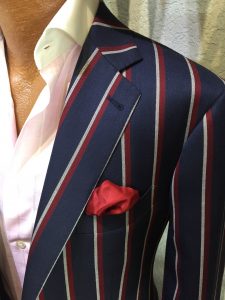 A man in a suit and tie with a red pocket square.