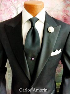 A suit and tie with a flower lapel pin.