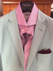 A suit and tie with pink shirt on it.