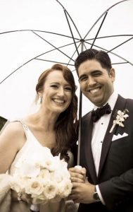 A man and woman standing under an umbrella.