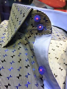 A close up of the collar and buttons on a shirt.