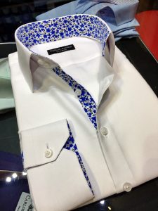 A white shirt with blue floral trim on it.