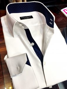 A white shirt with blue polka dots on the inside of it.