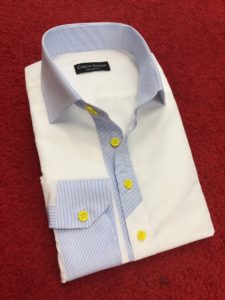 A white shirt with blue and yellow buttons.