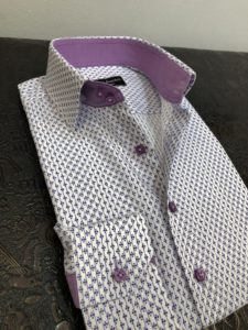 A purple and white shirt is on top of a table.