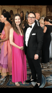 A man and woman in formal wear posing for the camera.