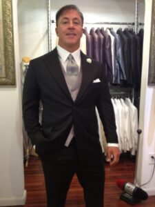 A man in a suit and tie standing next to a closet.