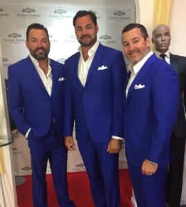 Three men in suits posing for a picture.