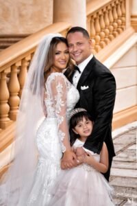 A man and woman posing with their daughter.