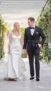 A man and woman walking down the street holding hands.