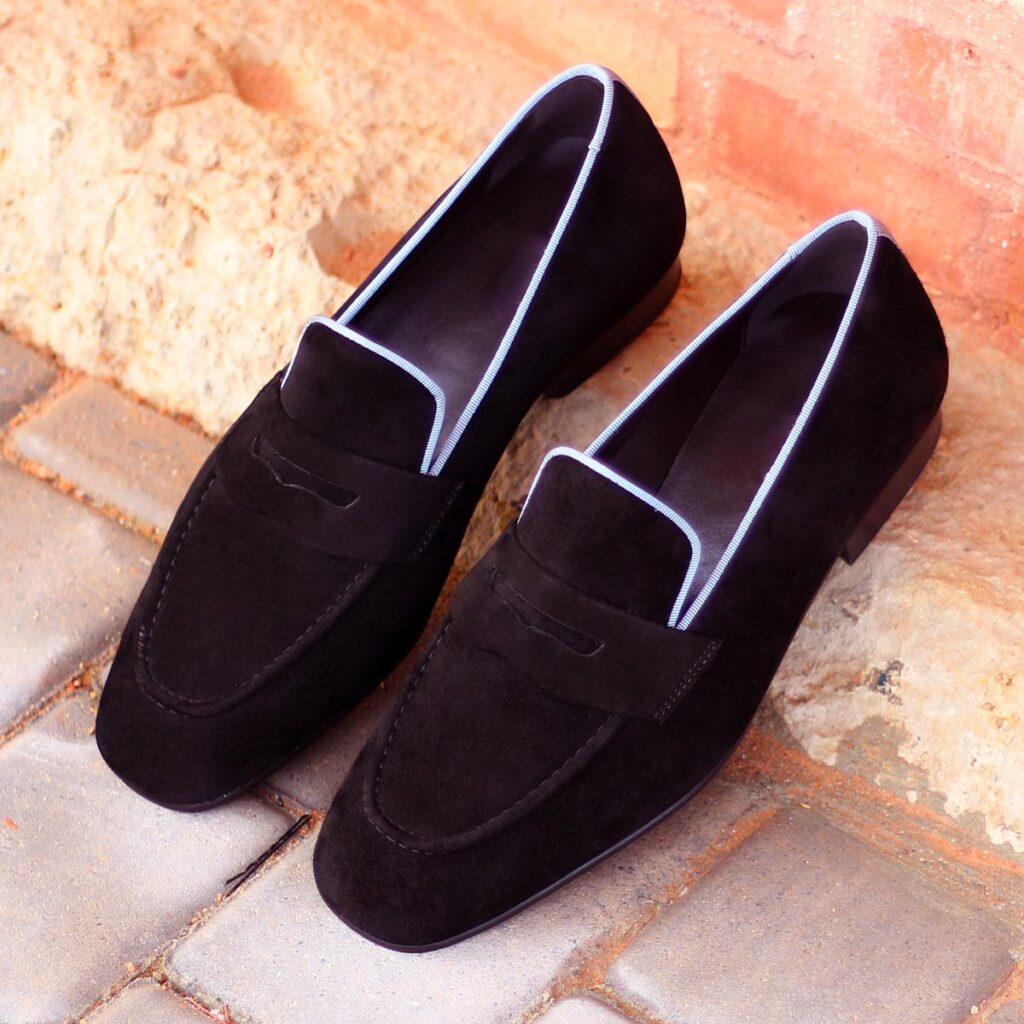 A pair of black shoes sitting on top of brick.
