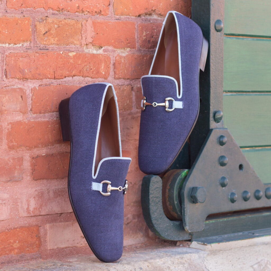 A pair of blue shoes hanging on the side of a building.