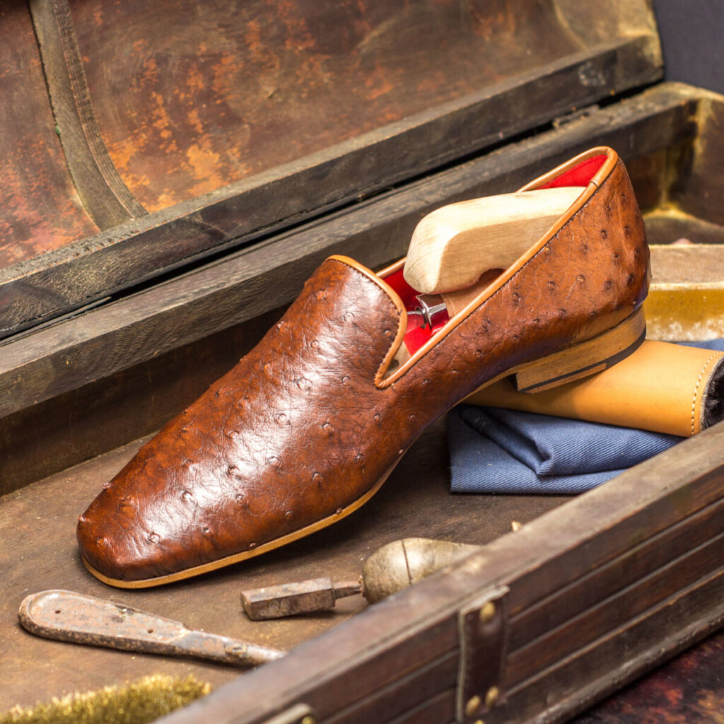 A brown shoe sitting on top of a wooden box.
